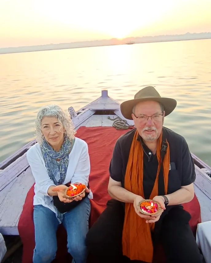 Guests holding flower lamps during a private sunrise boat ride on the Ganges in Varanasi